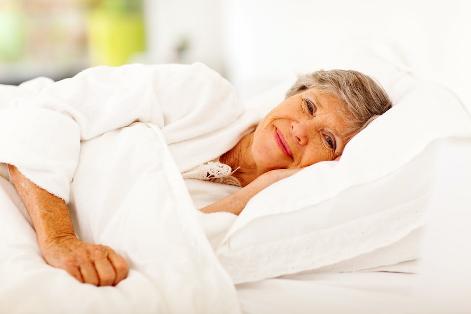 happy senior woman sleeping in when adjusting to retirement