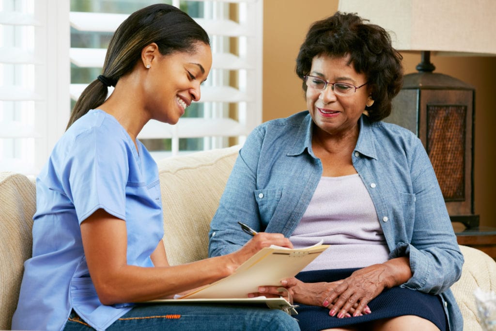 nurse helping elderly patient with paperwork in 55+ communities in Minnesota