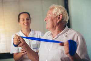 senior man uses exercise strap for activity
