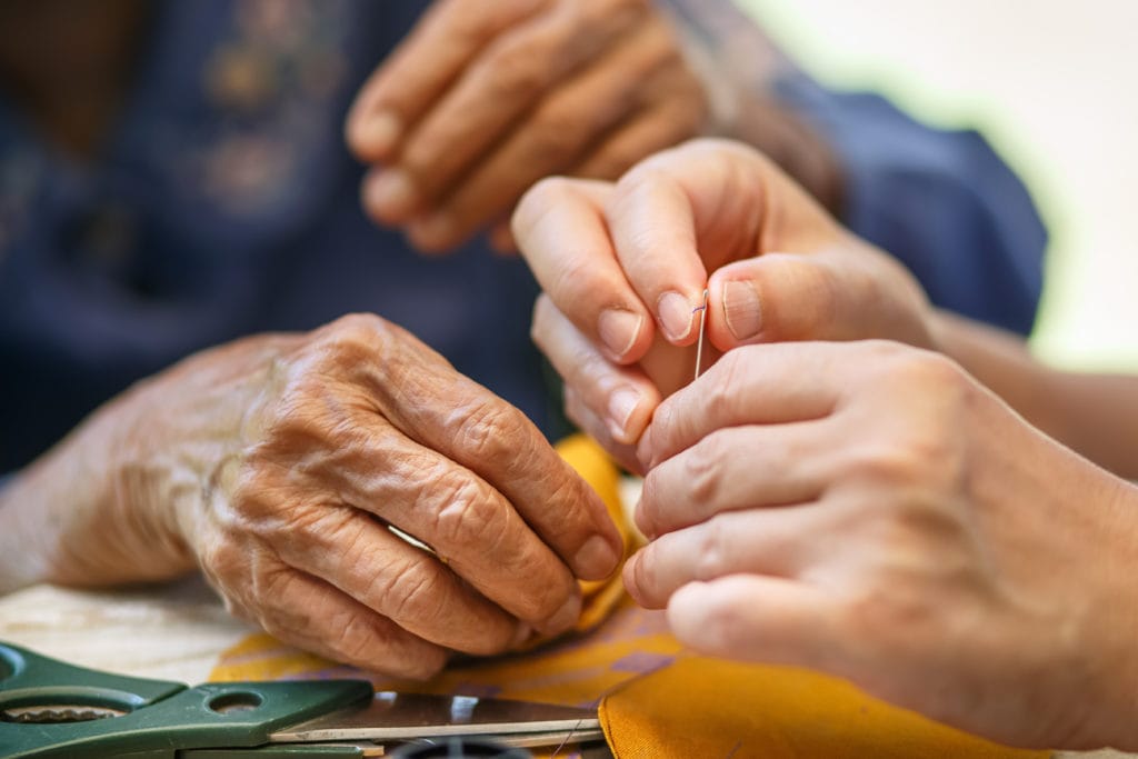 young man tending to an elderly man dealing with dementia symptoms; benefits of occupational therapy