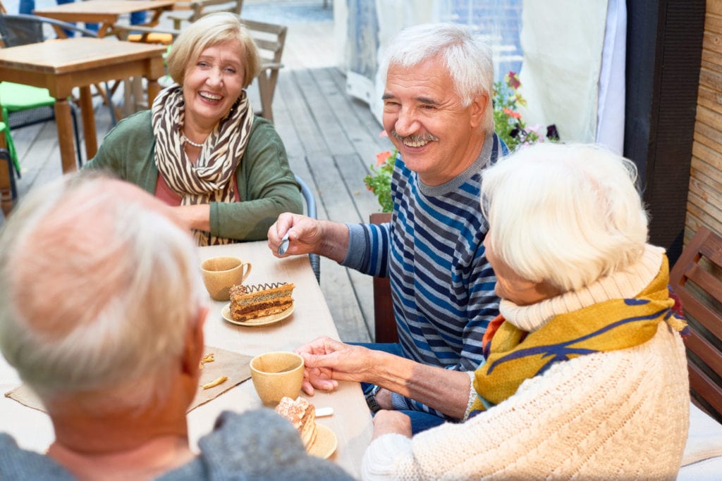 older couple and friends enjoying coffee at 55+ community in Minnesota