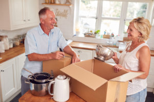 senior couple packing to move and downsize after retirement
