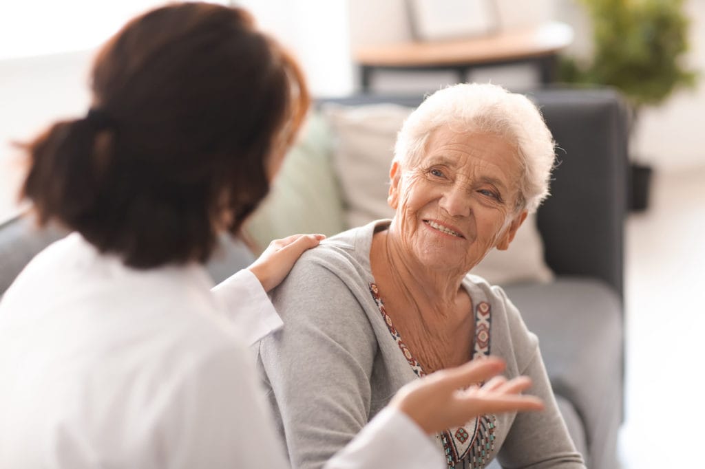 a young doctor discussing behavioral health programs with an elderly patient