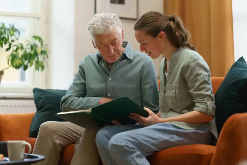 younger woman volunteers at nursing home and hangs out with resident.