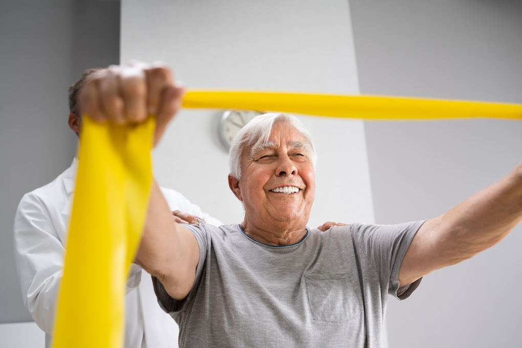 Physical Therapy Patient Using Physiotherapy Bands For Rehabilitation