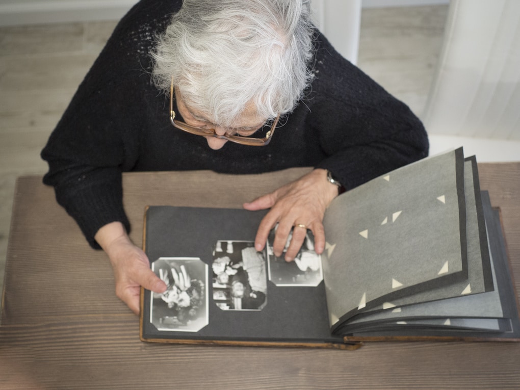 Elderly woman looking through old photographs as one of the activities for people with dementia 