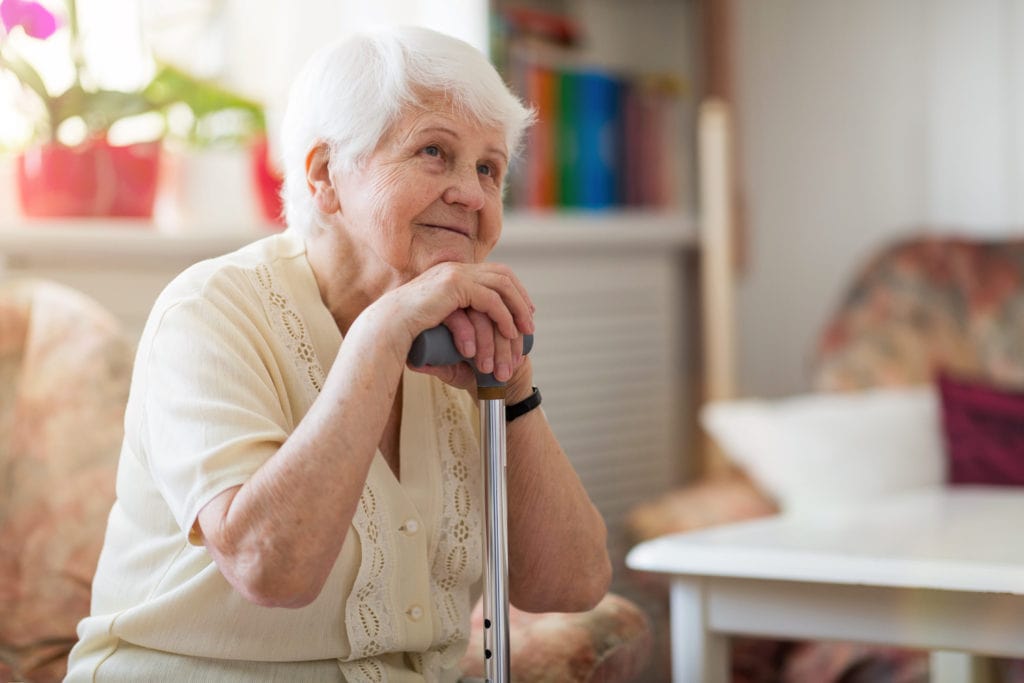 woman with early stages of dementia sits in her room at memory care