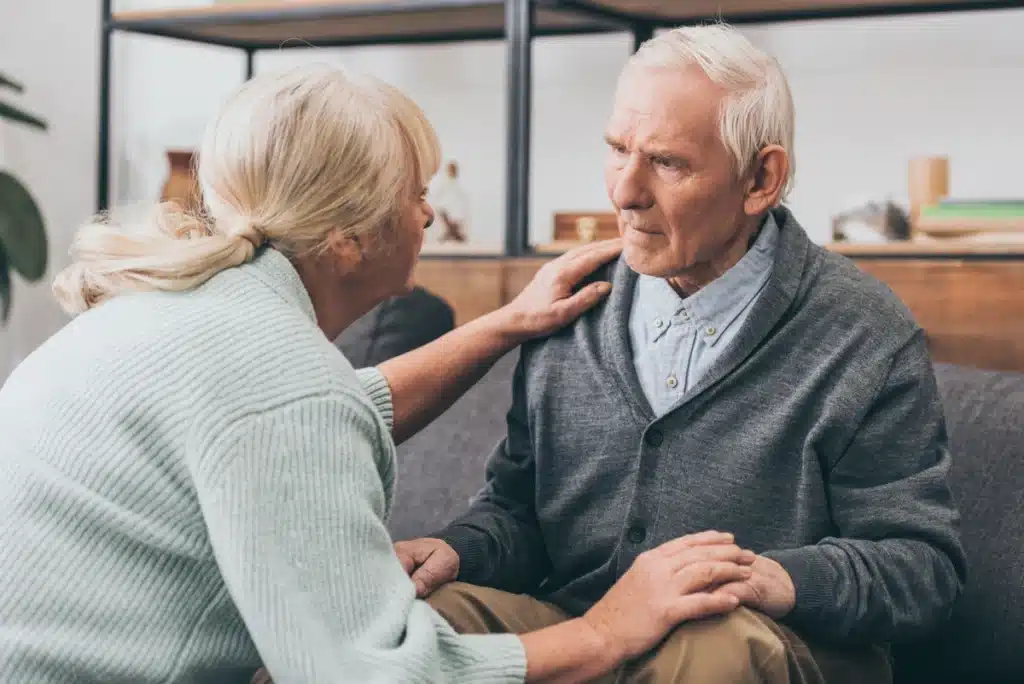 elderly man in middle stages of dementia is soothed by nurse