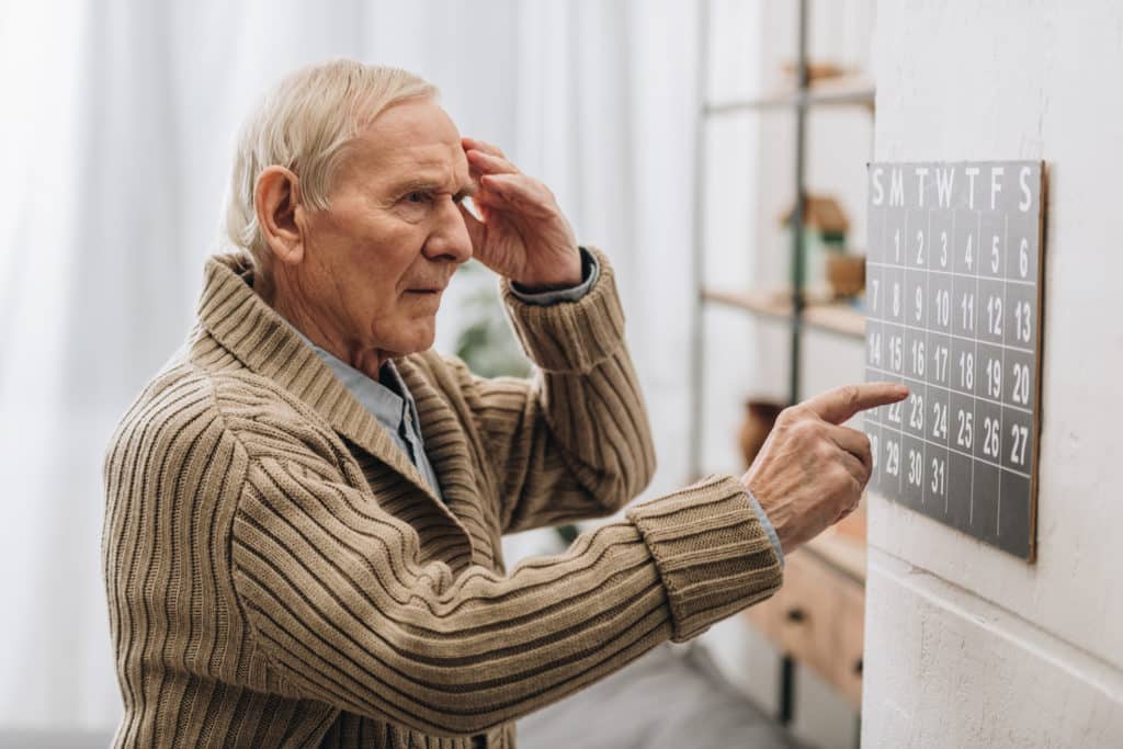 early signs of dementia man looks at calendar confused