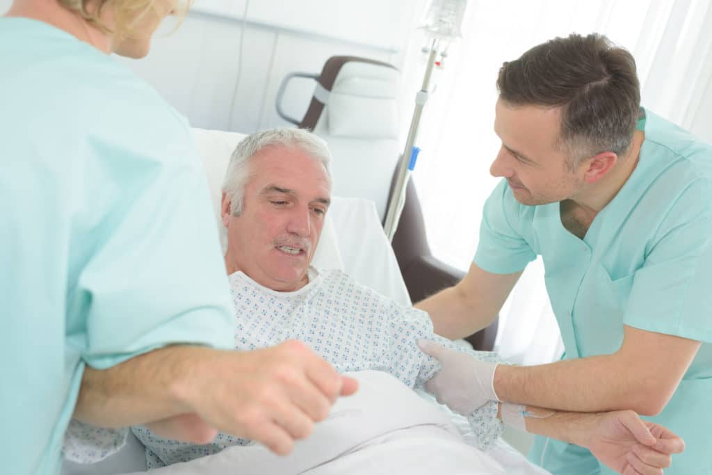 person with dementia getting combative and being held down by two nurses