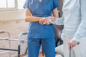 nurse helping elderly woman to walk