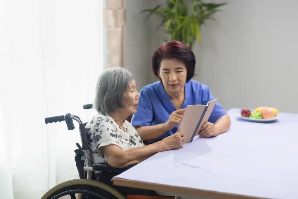 elderly woman reading aloud with nurse for dementia therapy