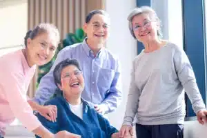 group of elder people laughing together in assisted living community