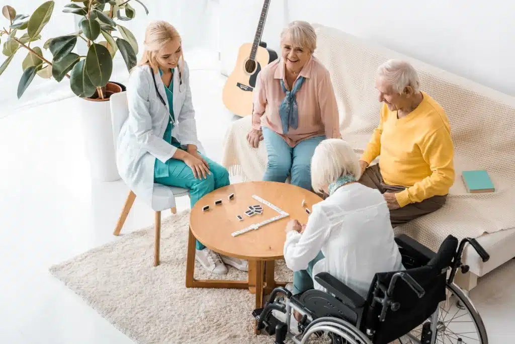 young caregiver playing domino with senior woman and man