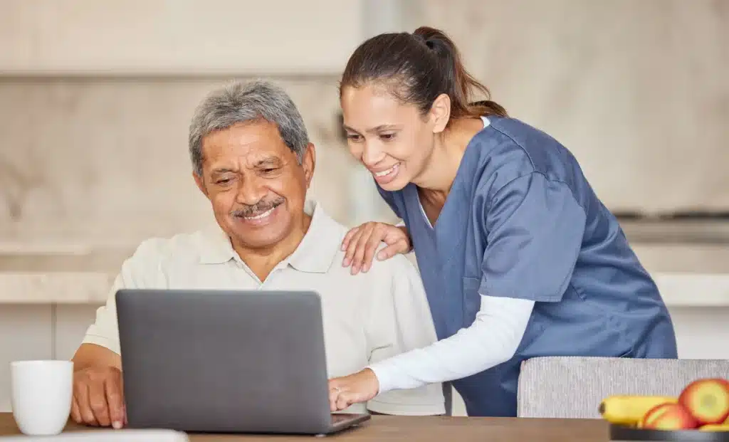 nurse showing medical results to senior on laptop
