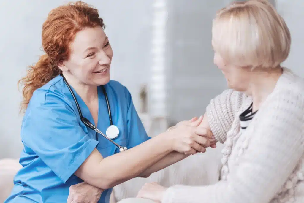 a nurse rolls up the sleeve of an elderly patient