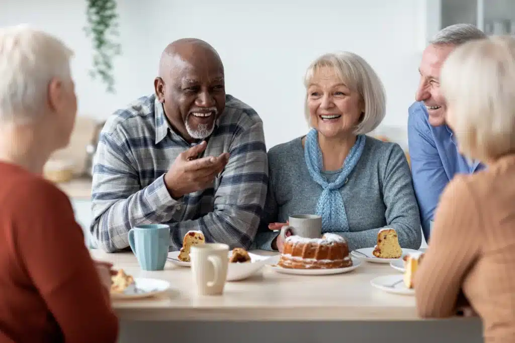 Senior citizens talk over coffee and cake