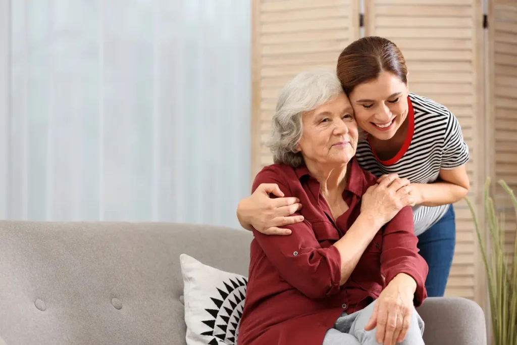 younger woman hugging an elderly woman