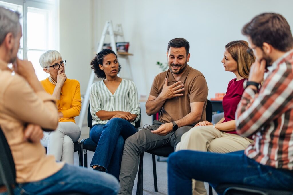 An adult man talking about his mental health, looking emotional.