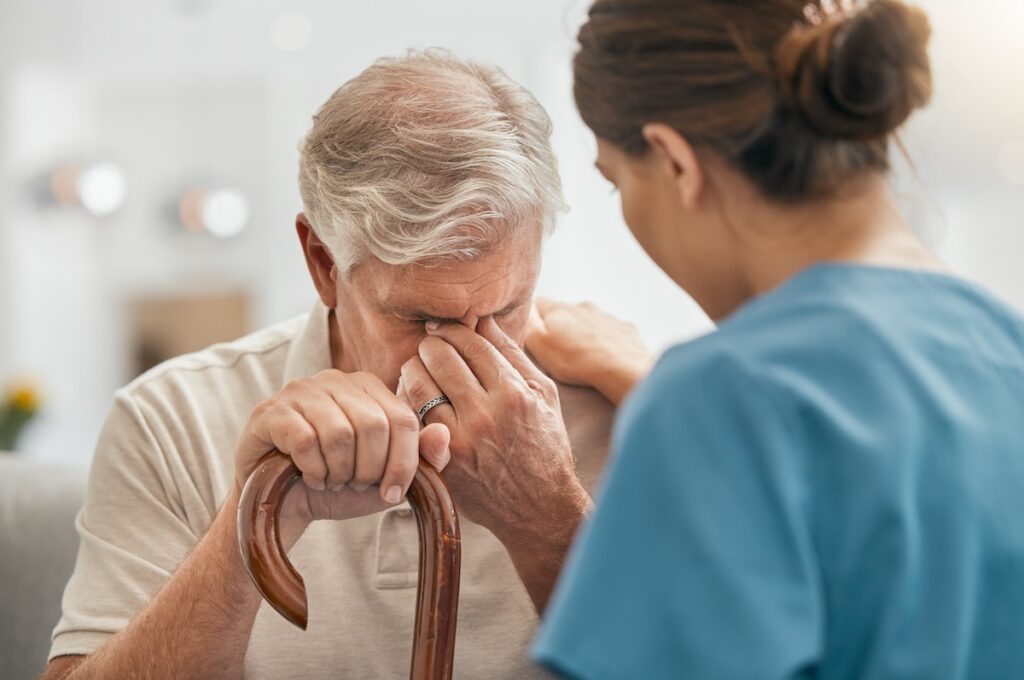 elderly man in pain, nurse comforting him