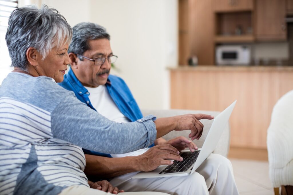 couple using laptop in living room