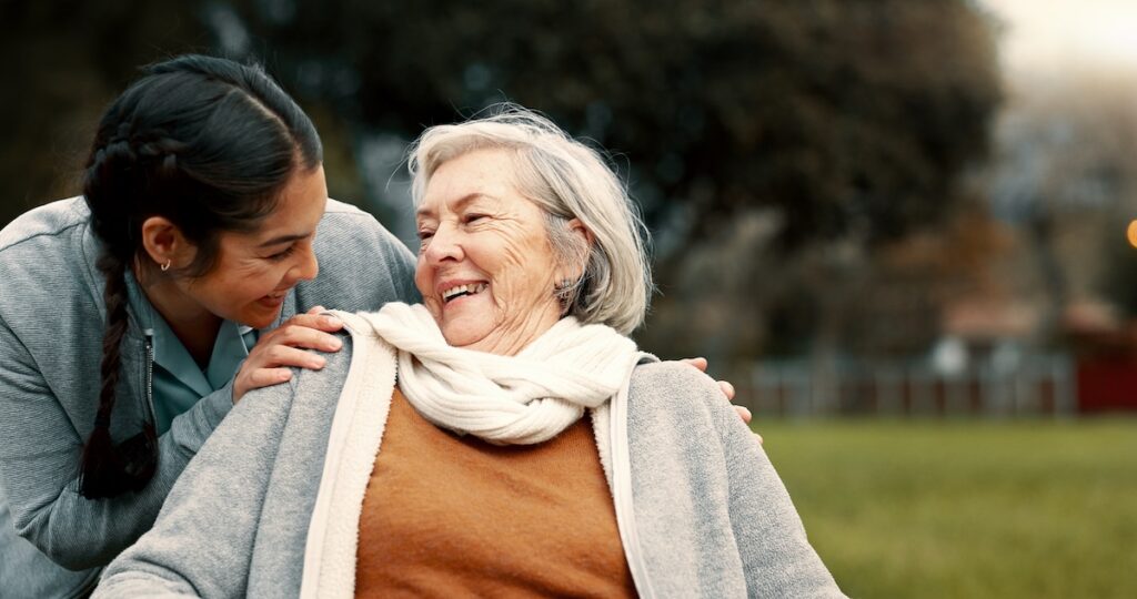 Caregiver helping woman with disability in park for support, trust and care in retirement